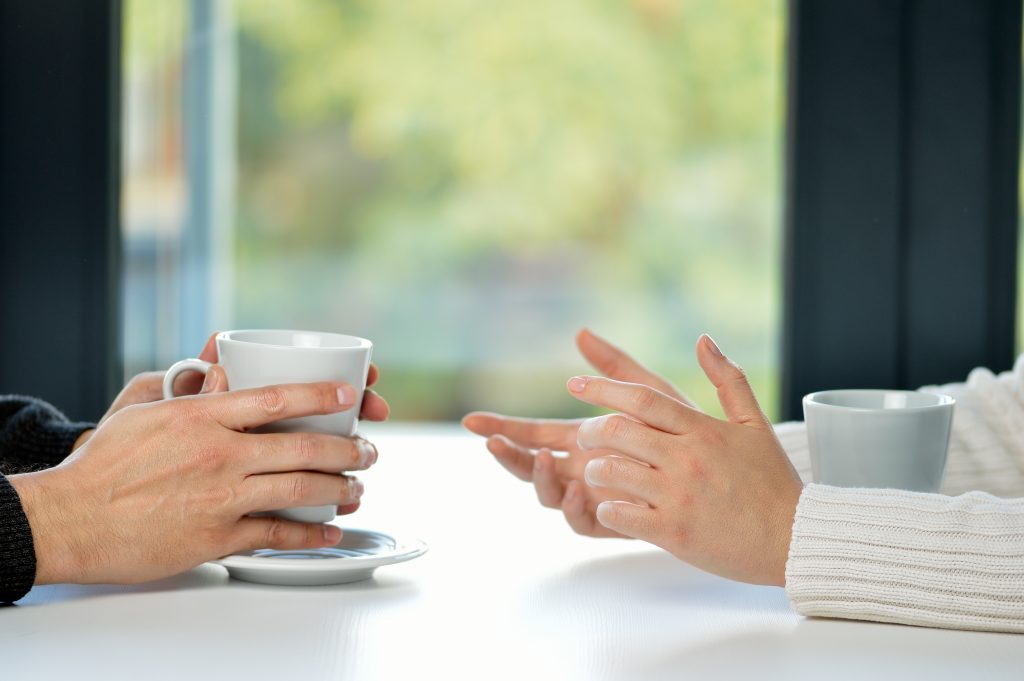 Hands of two people taking with coffee