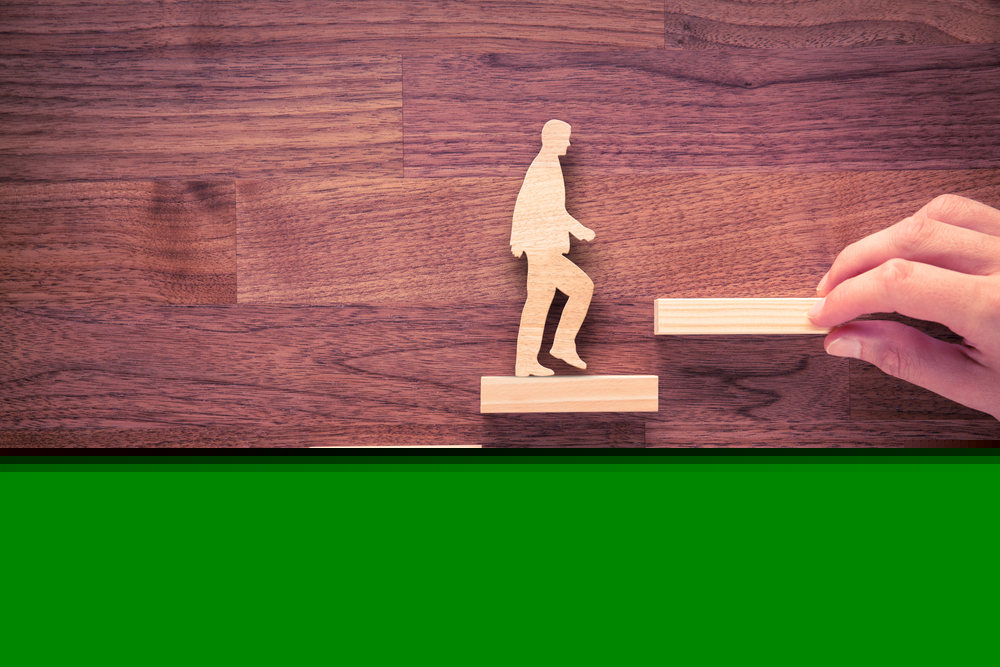 A figure of a man made from wood walking up stairs